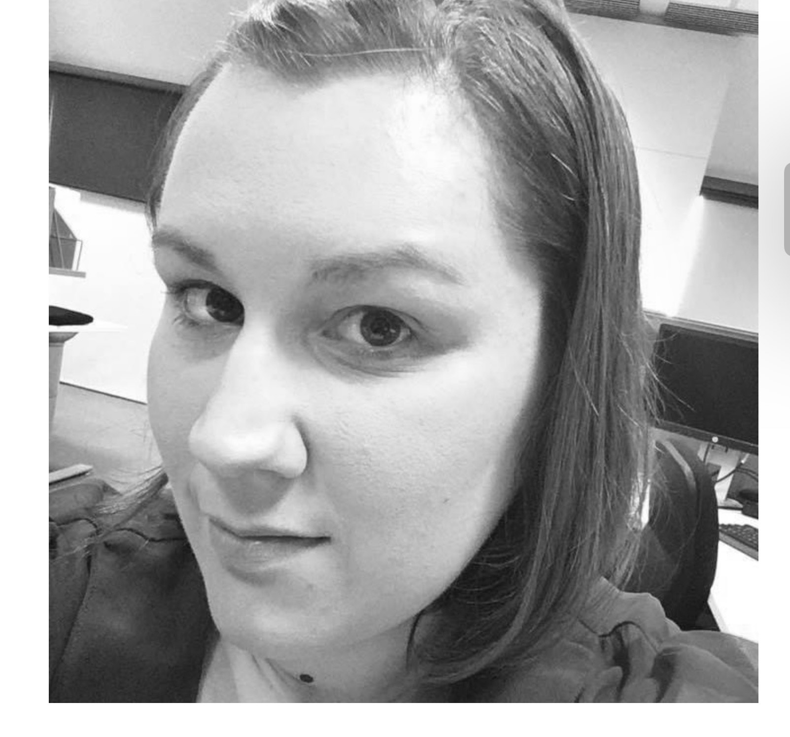 Image of Crystal in black and white. Crystal is looking at the camera and has shoulder length hair.
