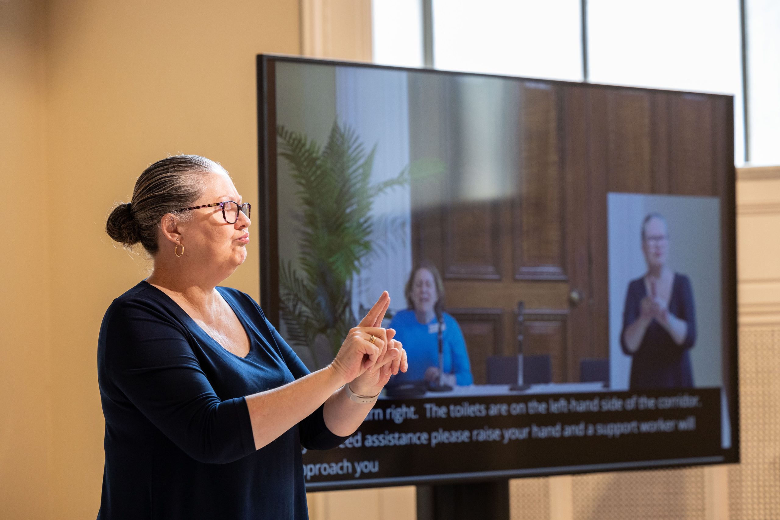 Our awesome interpreter stands in front of the room as CEO at the time, Nadia Mattiazo speaks