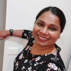 Jayashree is smiling at the camera and wearing a floral top.